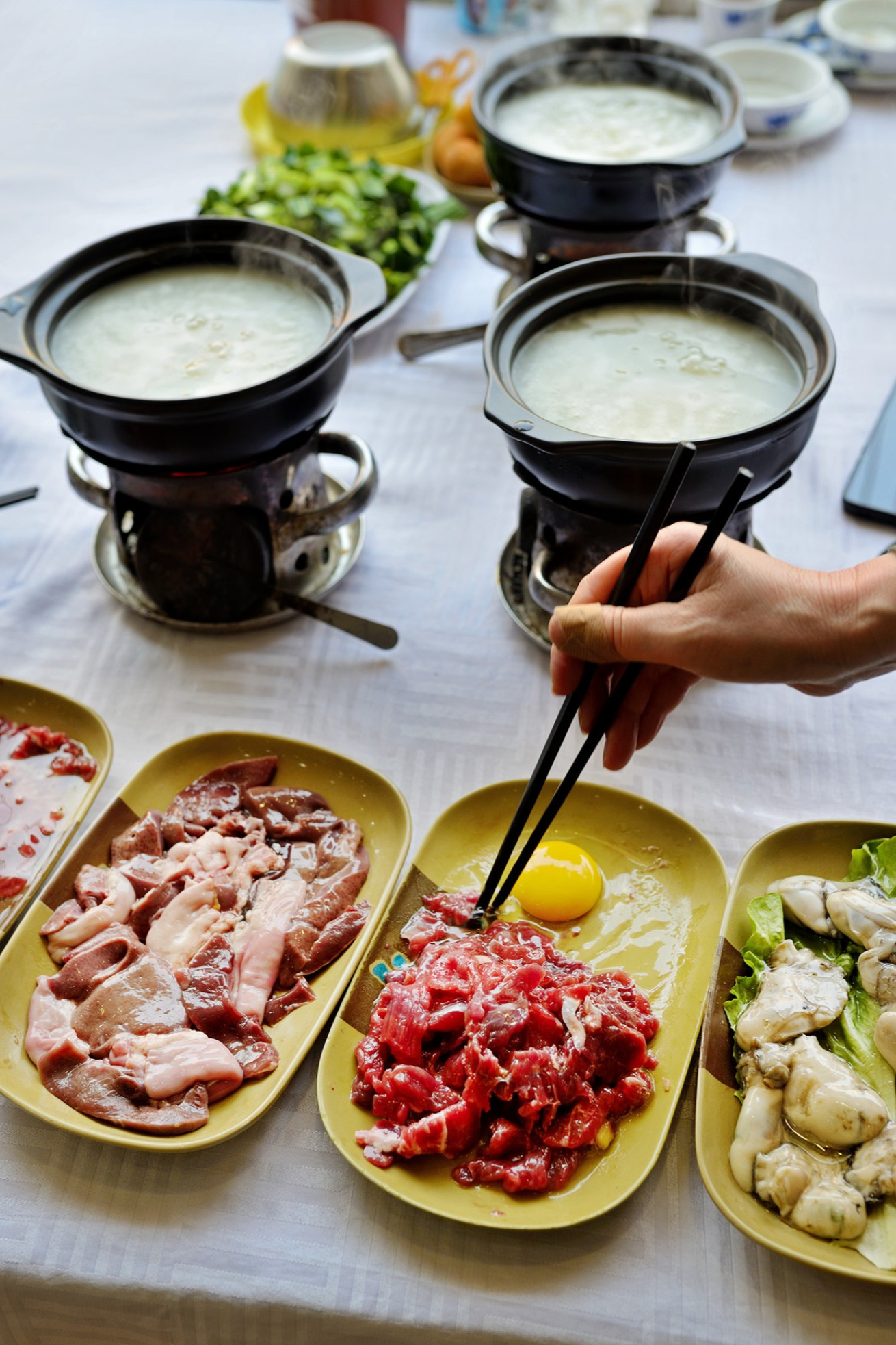  A bubbling Wu Mi Zhou (congee base) hot pot with various ingredients ready to be cooked