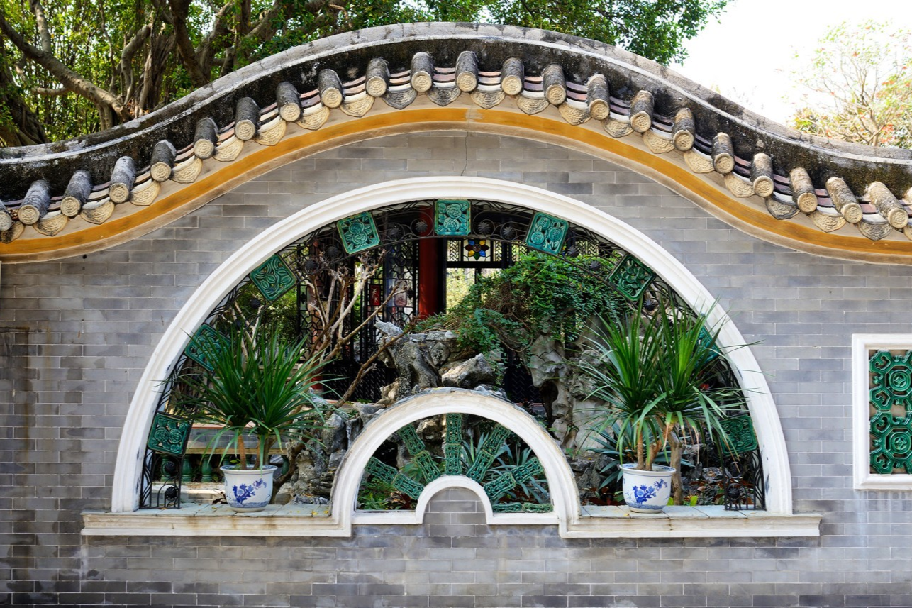  A decorative window or doorway in Qinghui Garden framing a view beyond
