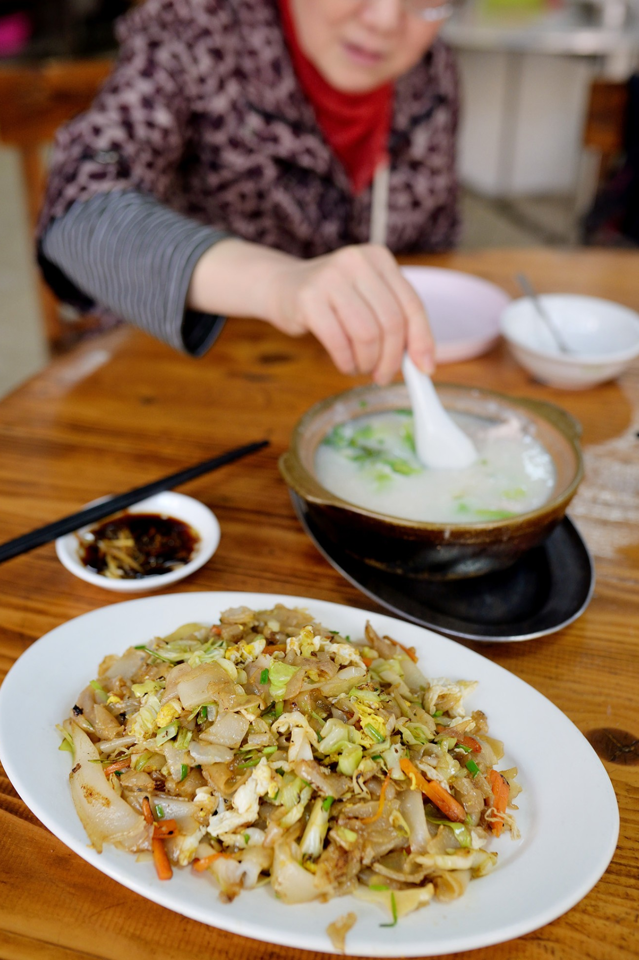  A serving of freshly-cooked congee and a plate of stir-fried rice noodles with wok hei
