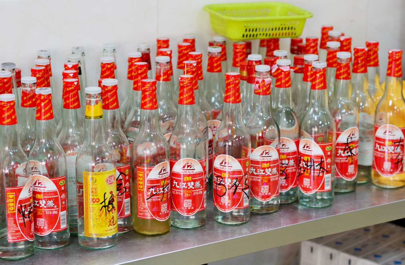  Bottles of Jiujiang Double Steamed Rice Wine, perhaps with markings, on a table