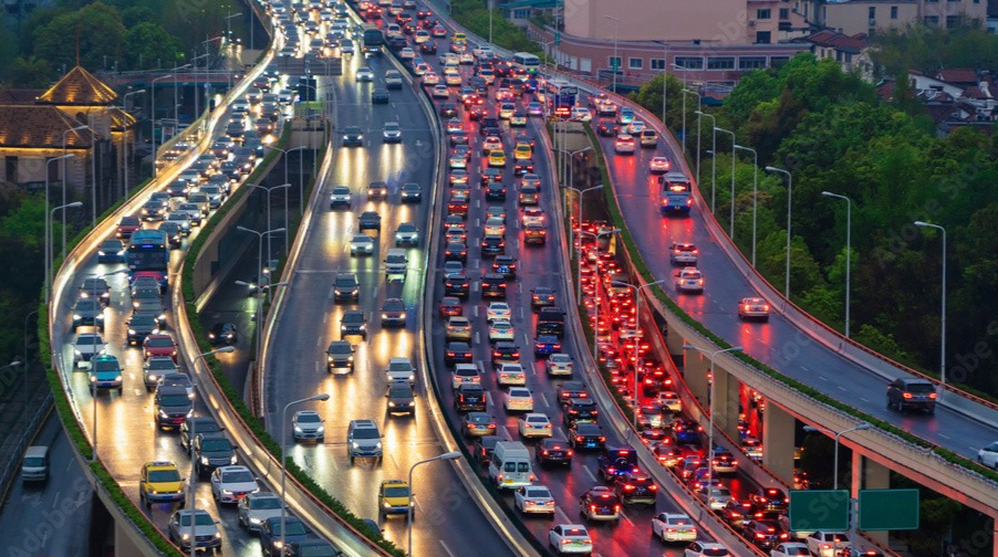 Cars driving on a busy urban road in China with visible signage