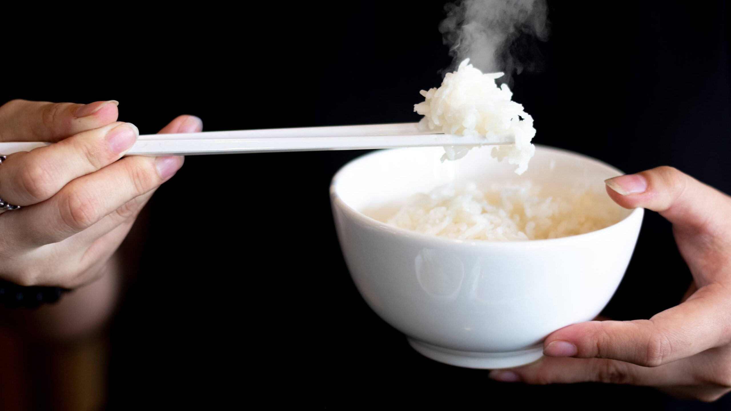 Close-up of proper chopstick grip with rice bowl