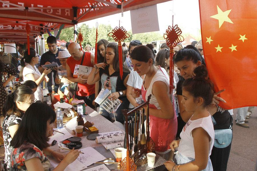 Diverse group of people smiling and interacting at a cultural exchange event
