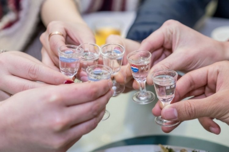 Group toasting with baijiu glasses at a Chinese banquet