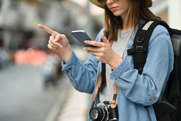  Happy tourist using smartphone in front of Shanghai skyline