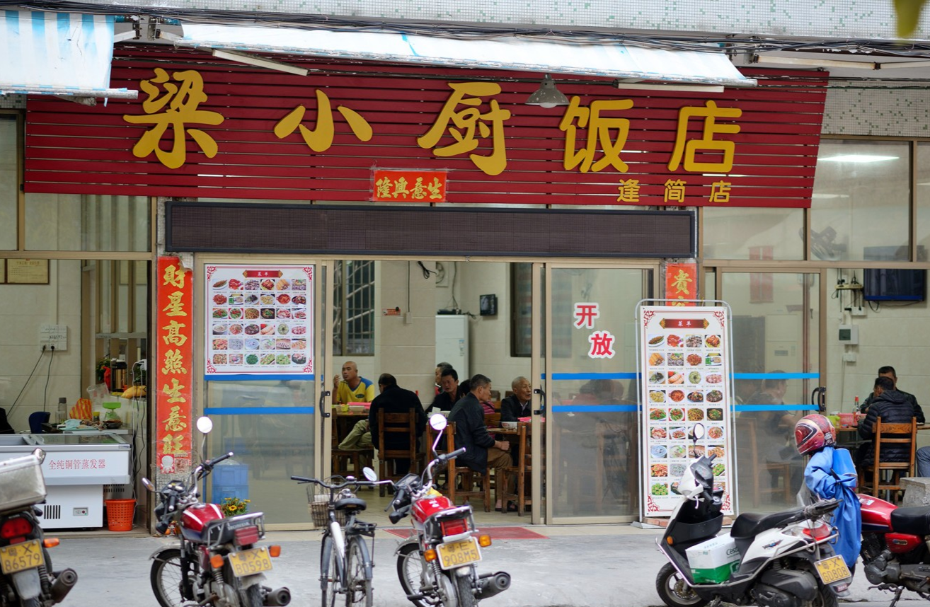  Interior of Liang Xiao Chu, with locals enjoying breakfast, possibly showing congee and rice wine bottles