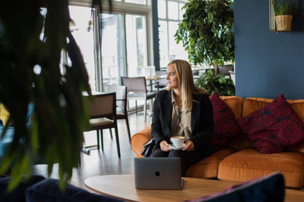 Modern hotel lobby with guests using laptops and smartphones