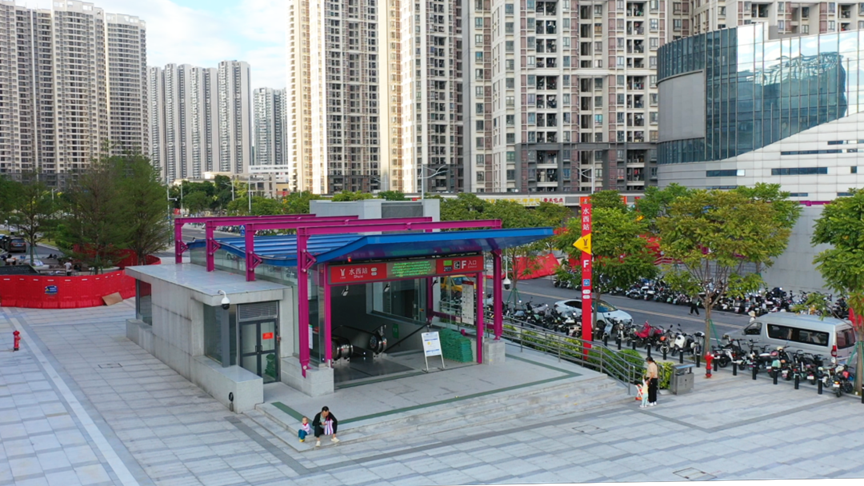 Panoramic view of a bustling Chinese city with various transportation options visible - subway entrance, buses, taxis and bicycles