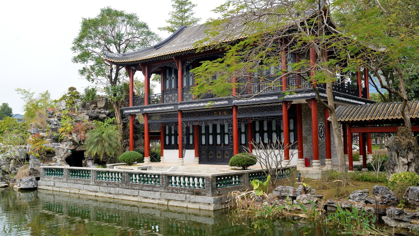  People walking or cycling on a path in Shunfengshan Park, surrounded by greenery