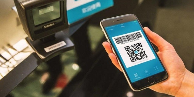 Tourist happily making mobile payment at a street market in China