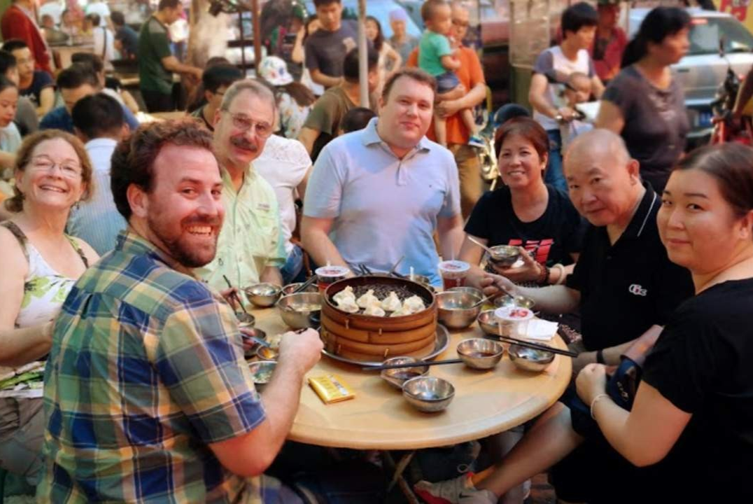 Tourist pointing at menu items with waiter