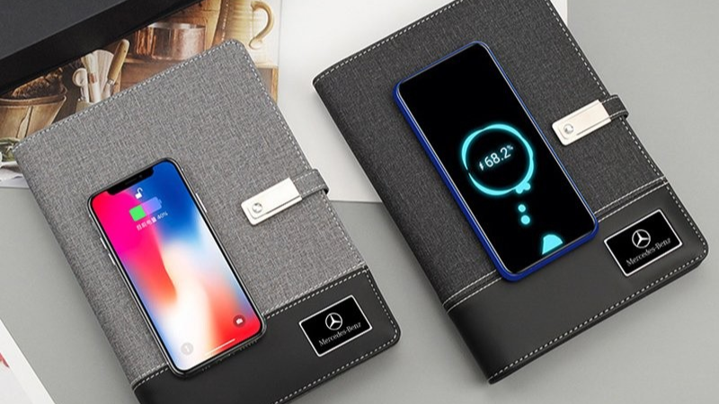 Travel essentials laid out - smartphone, power bank, charger, notebook with Chinese phrases