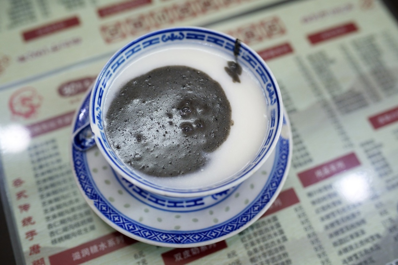  A bowl of the famous dessert, showing the distinct black sesame paste and white almond paste side-by-side before being mixed.
