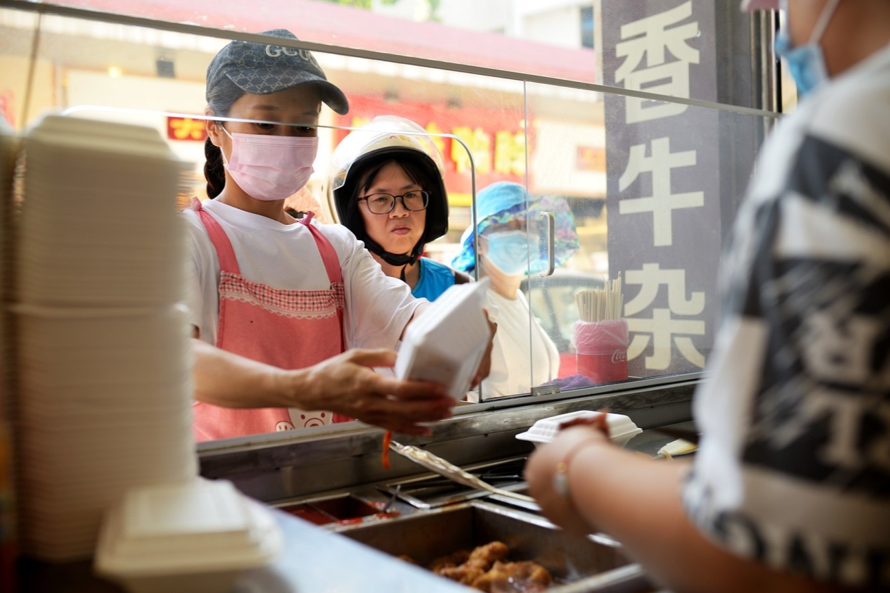  The iconic Ximei stall on Huagai Street, with a large pot of simmering beef offal in the foreground and the owner serving a customer. The scene should capture the authentic street food vibe.