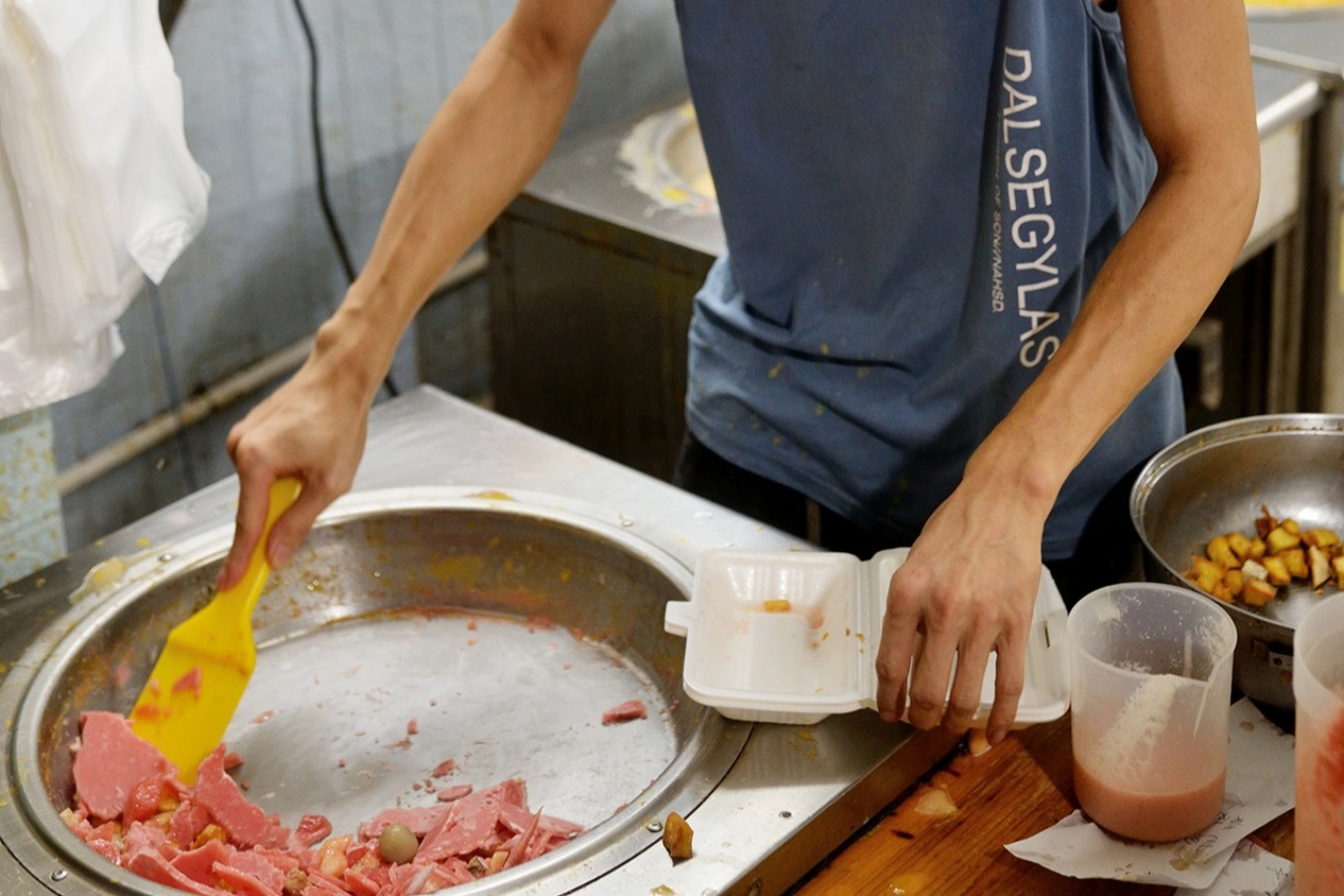  with spatulas scraping and chopping the freezing fruit puree on a circular