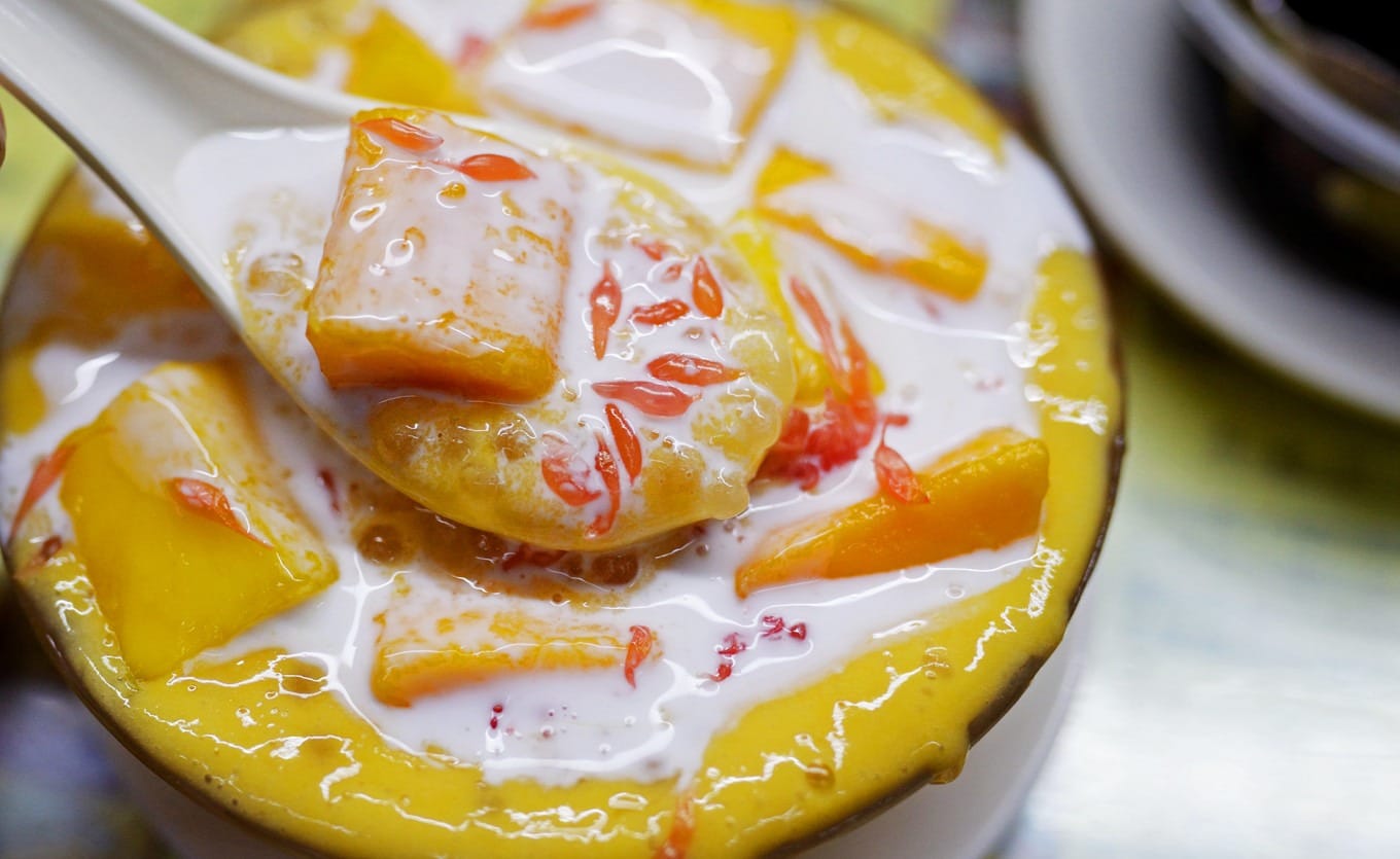 Close-up of Yangzhi Ganlu with large mango chunks and pomelo