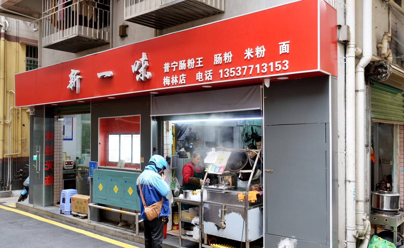 Small, crowded interior of Xinyiwei Puning Rice Noodle Rolls King in Shangmeilin
