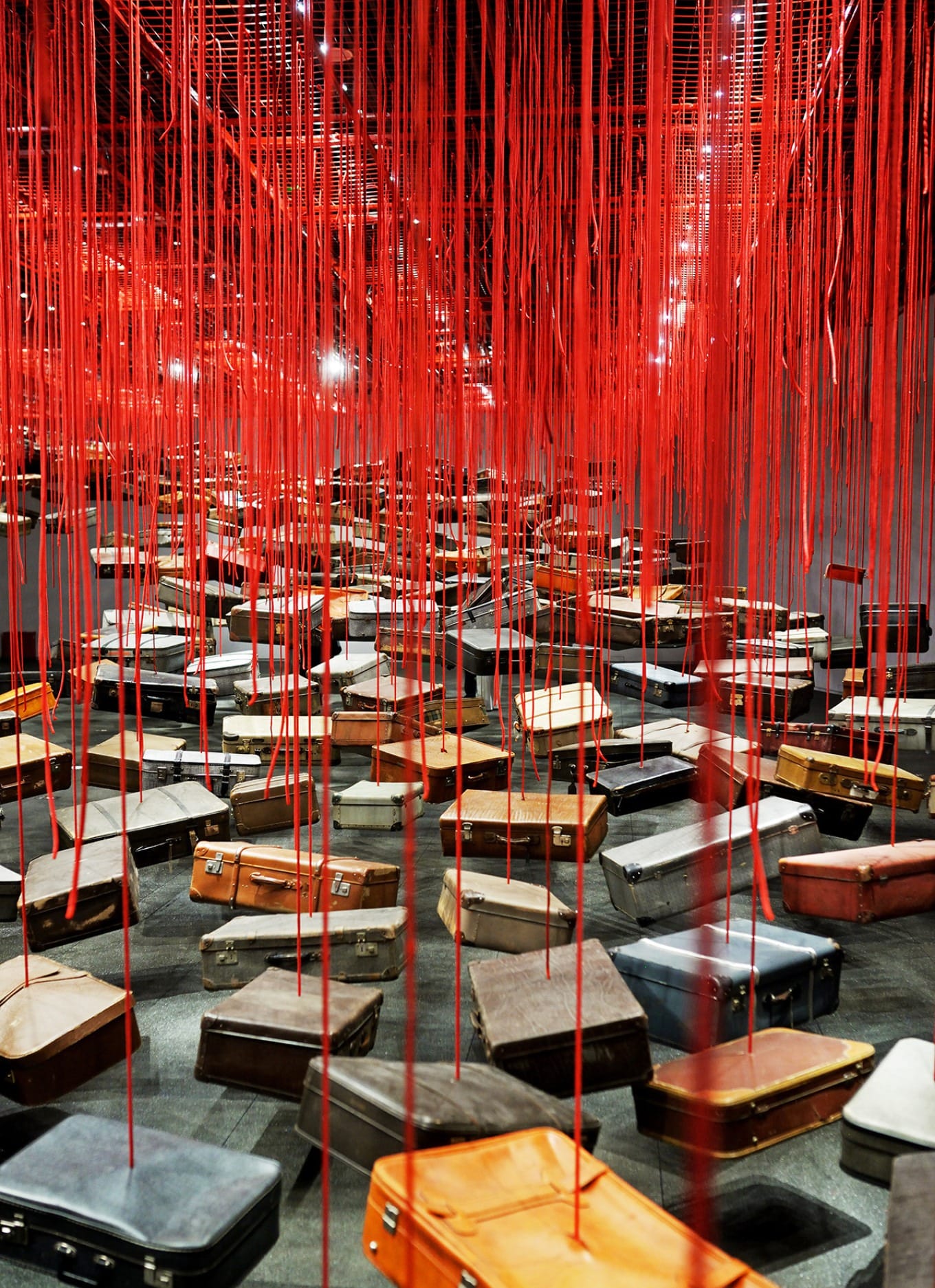 Installation Gathering Seeking Home with suspended suitcases