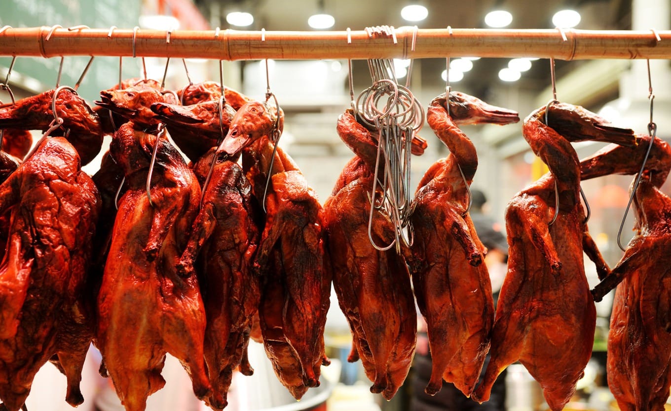 Roast duck simmering in Sichuan mao cai red oil broth