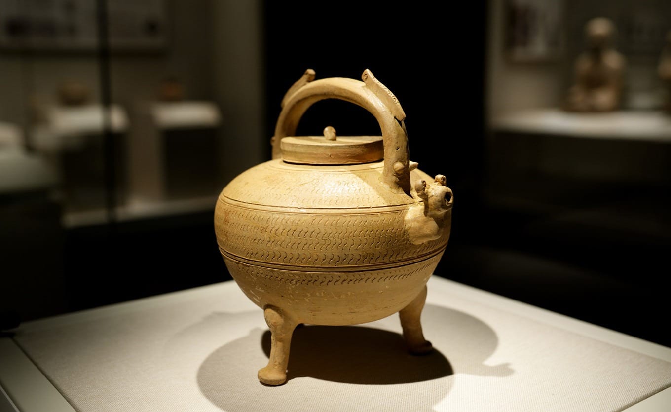 Proto-celadon three-legged wine vessel with dragon-shaped details