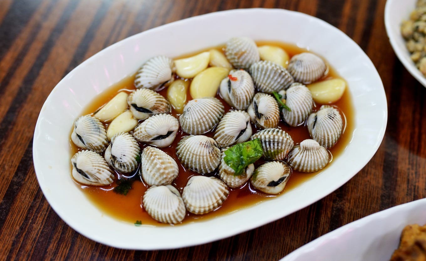 Raw marinated blood cockles showing their distinctive red juices