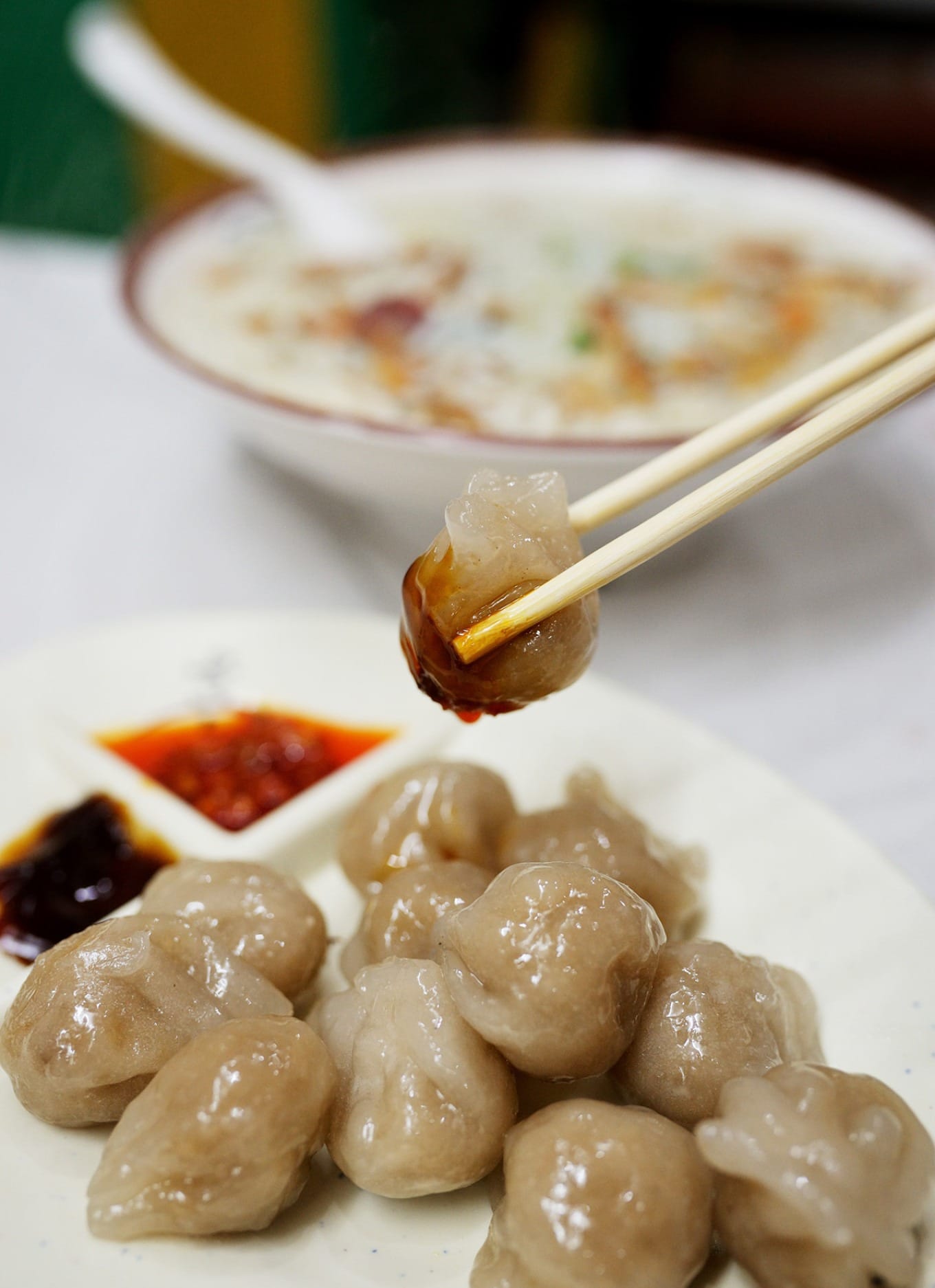 Haifeng Xiaomi dumplings served with chili sauce and oyster sauce for dipping