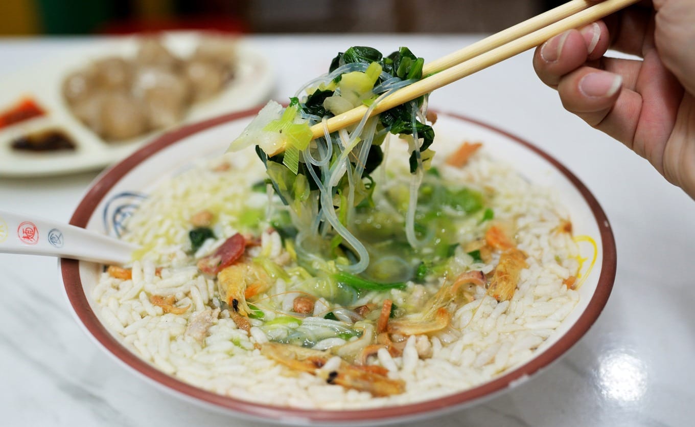 A bowl of Haifeng Cai Cha topped with toasted rice and dried seafood