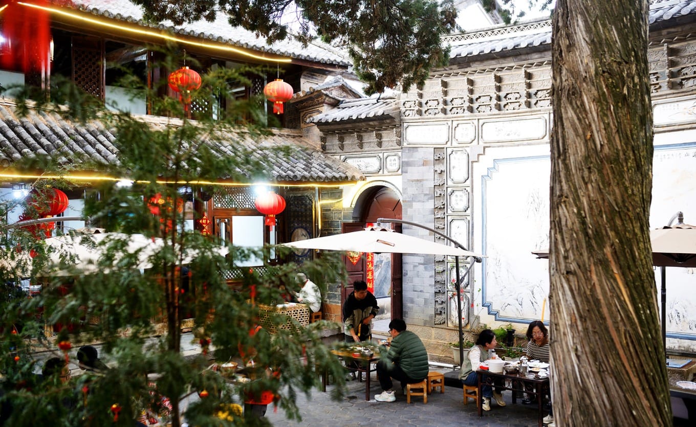 Exterior of Kunshifu Restaurant in a traditional courtyard setting on Housuo Street