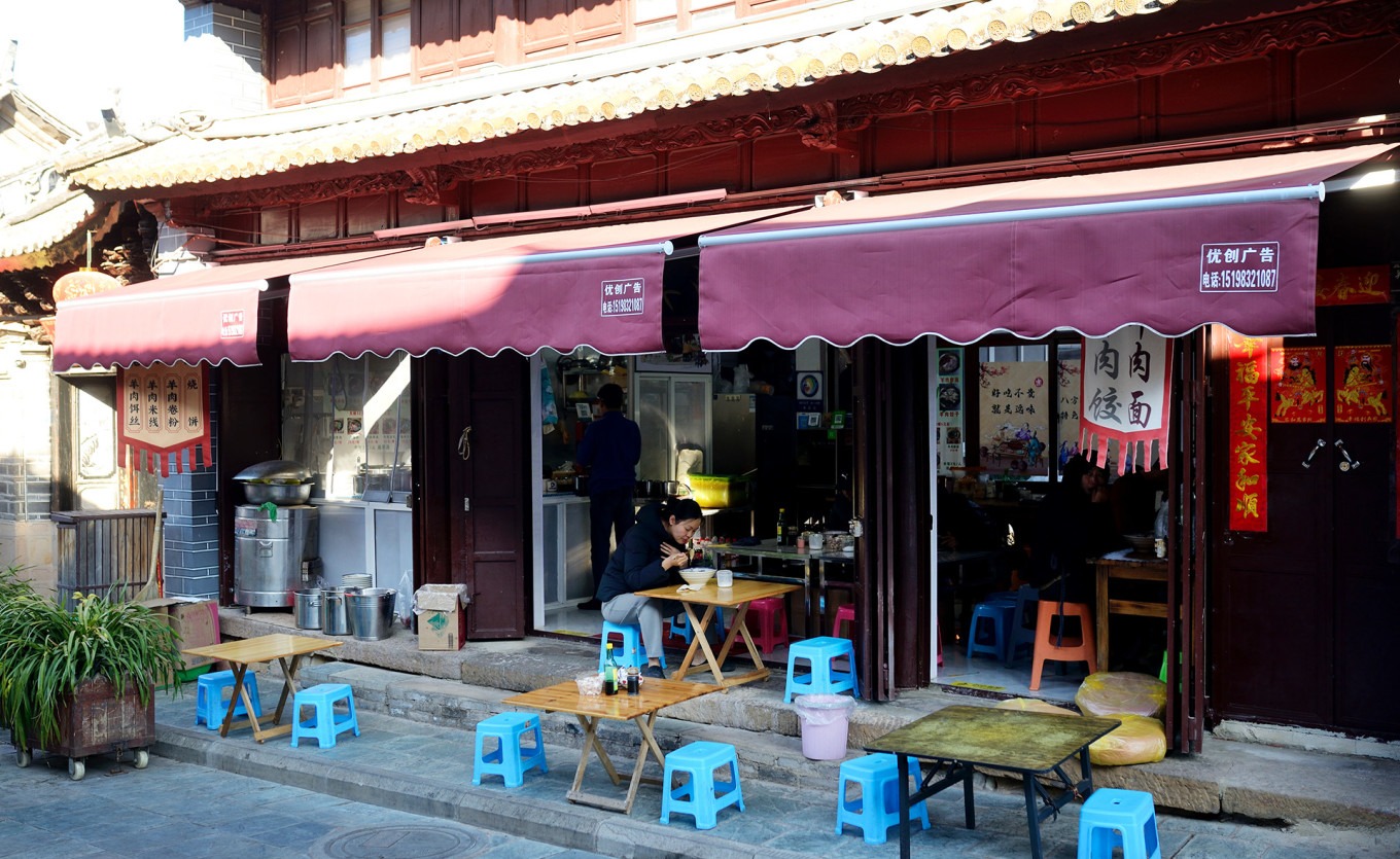 Interior of Yuan Shi Mutton Restaurant in Weishan, showing local customers enjoying their meals