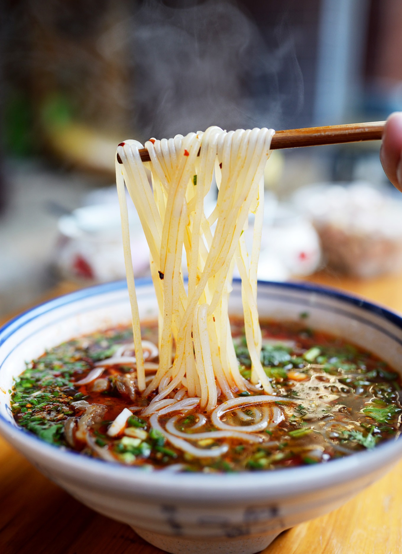 A bowl of mutton rice noodles with chili oil and herbs at Yuan Shi Mutton Restaurant