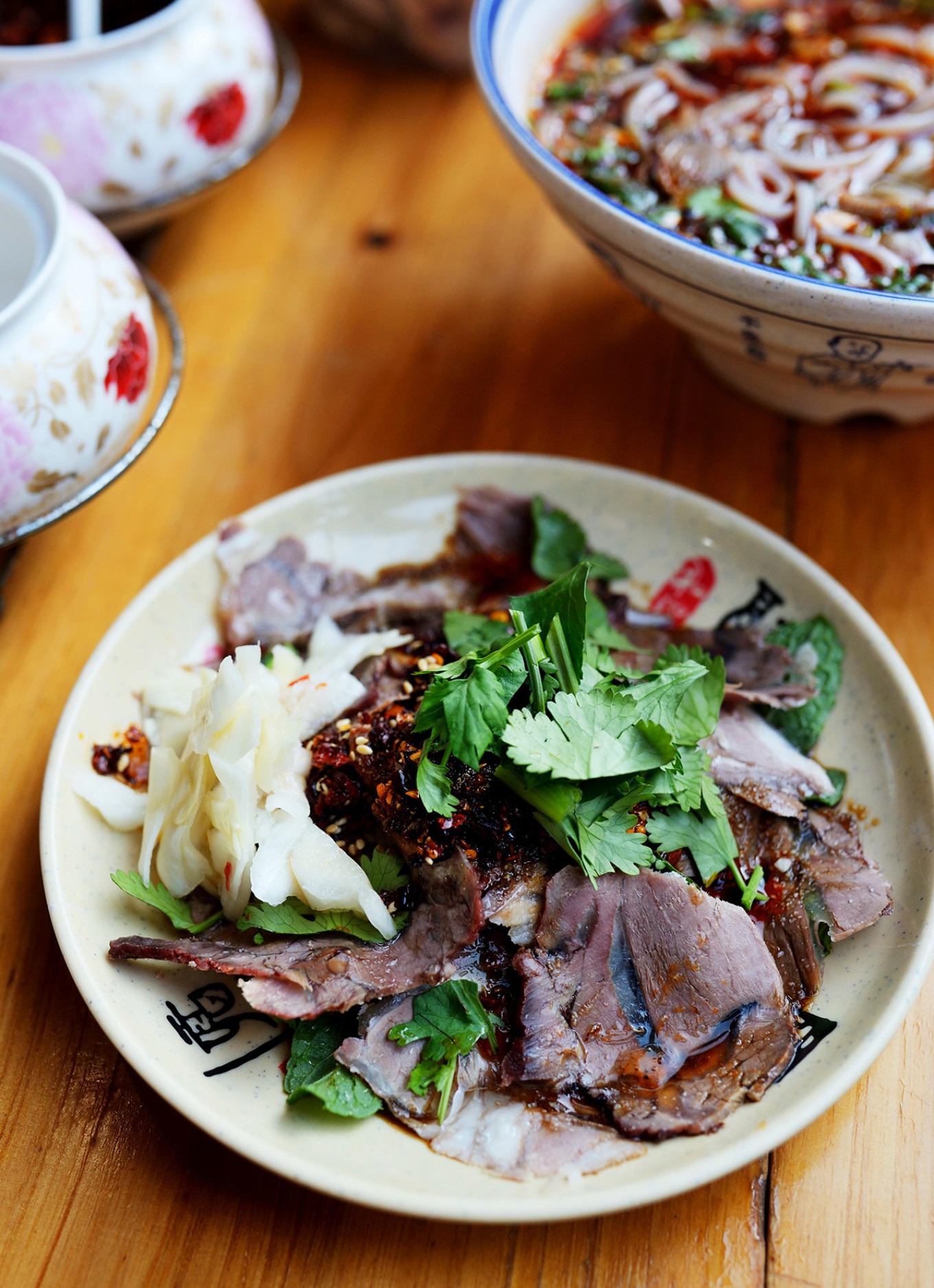 A plate of cold sliced mutton with chili oil dipping sauce