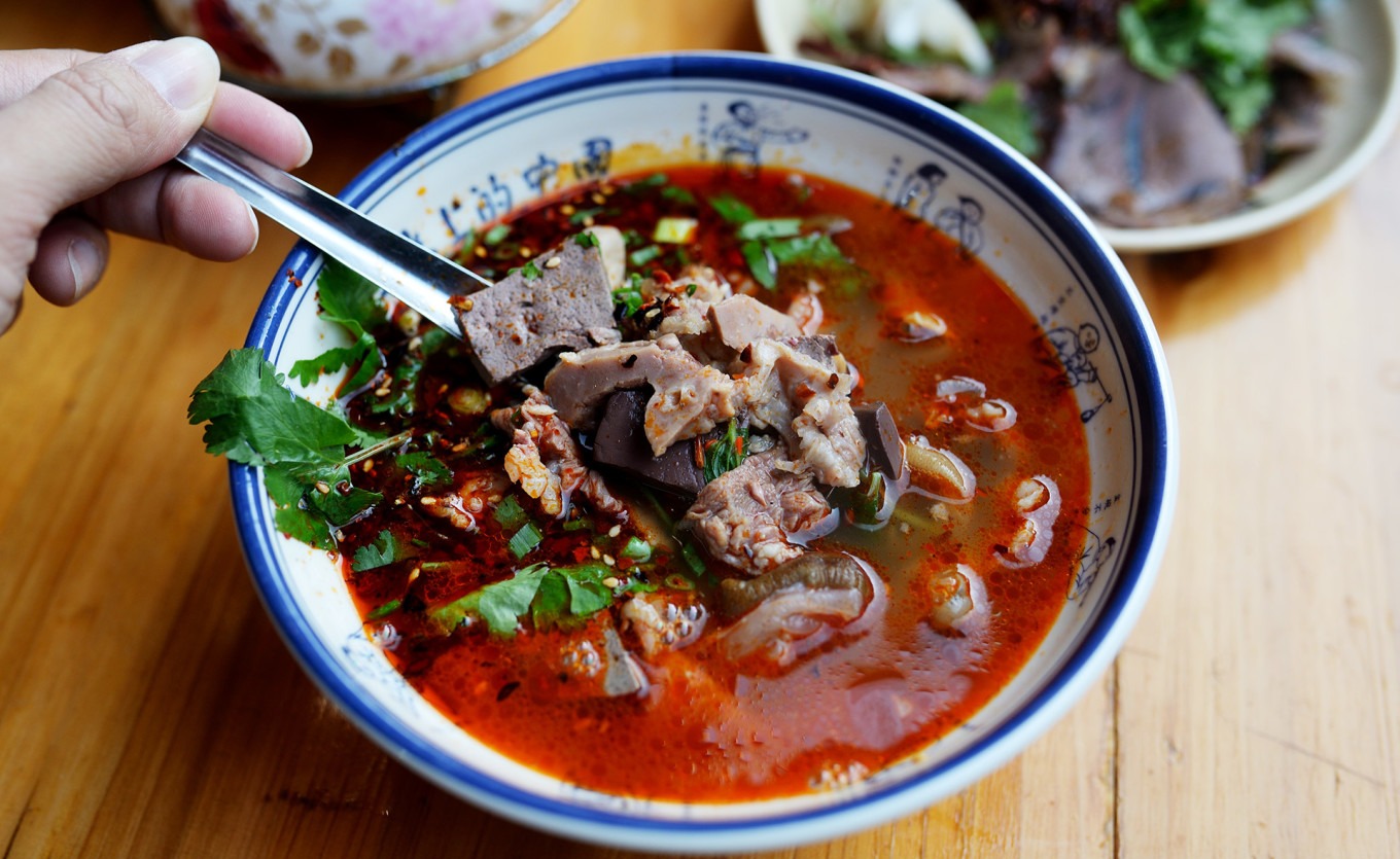 A steaming bowl of mutton offal stew with assorted organ meats