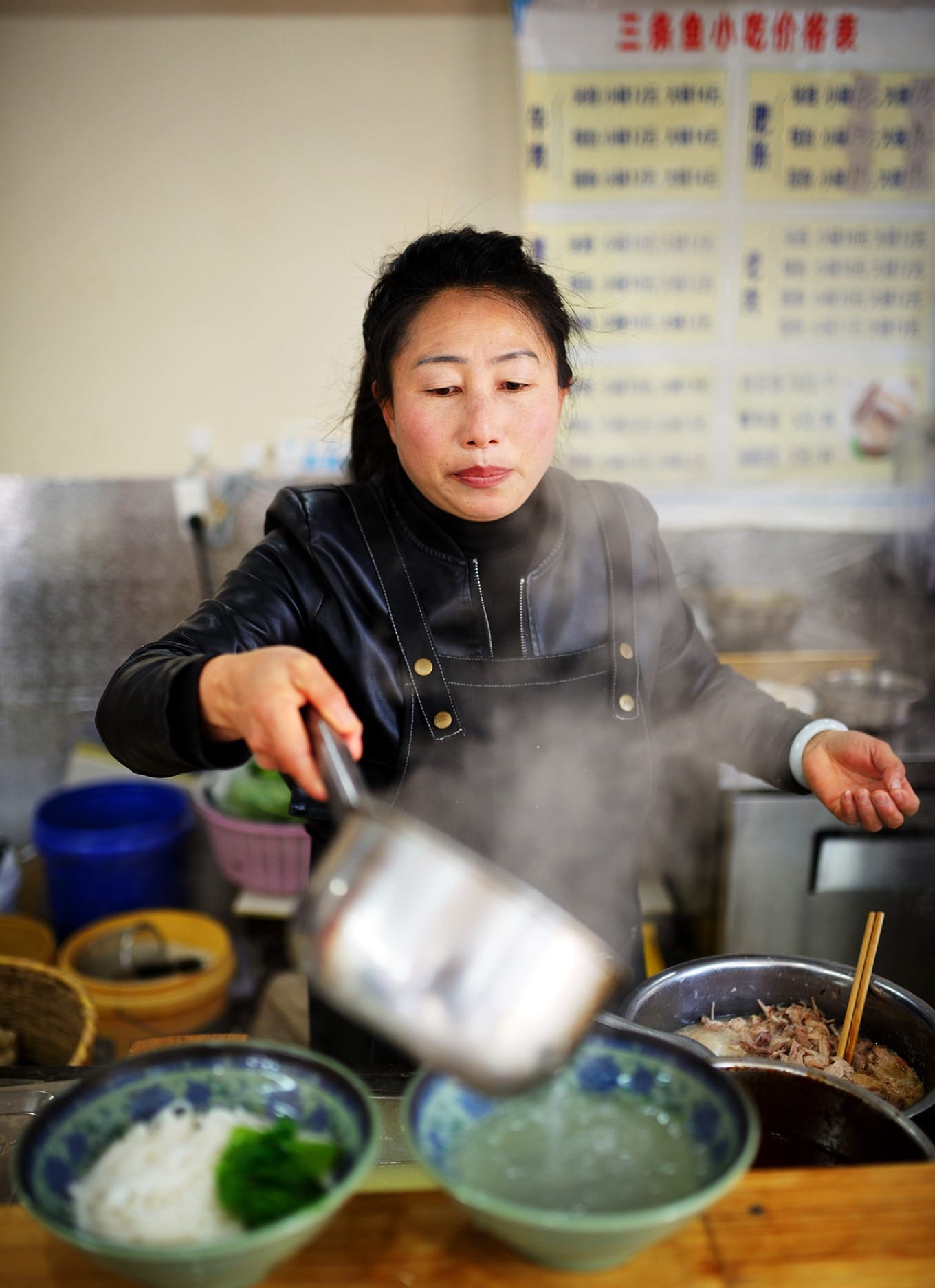 Close-up of a bowl of bā ròu ěr sī (pounded meat rice noodles) with broth and toppings
