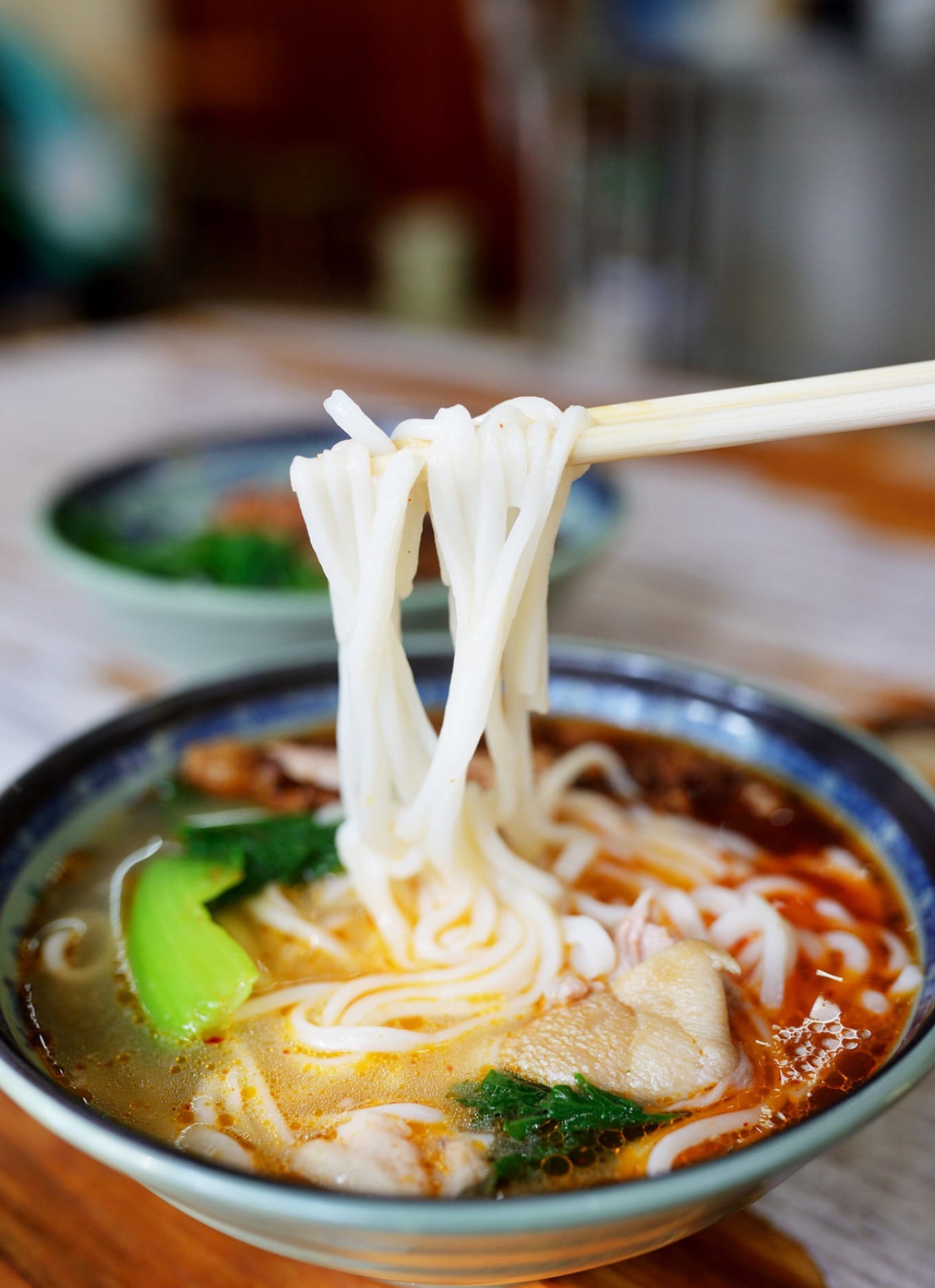 Chef preparing bā ròu (pounded meat) topping in the kitchen