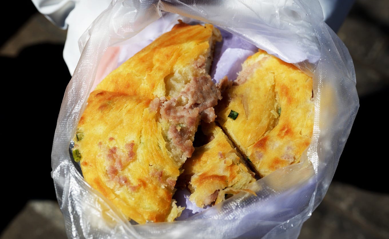 Freshly baked scallion and pork posu baba with flaky layers