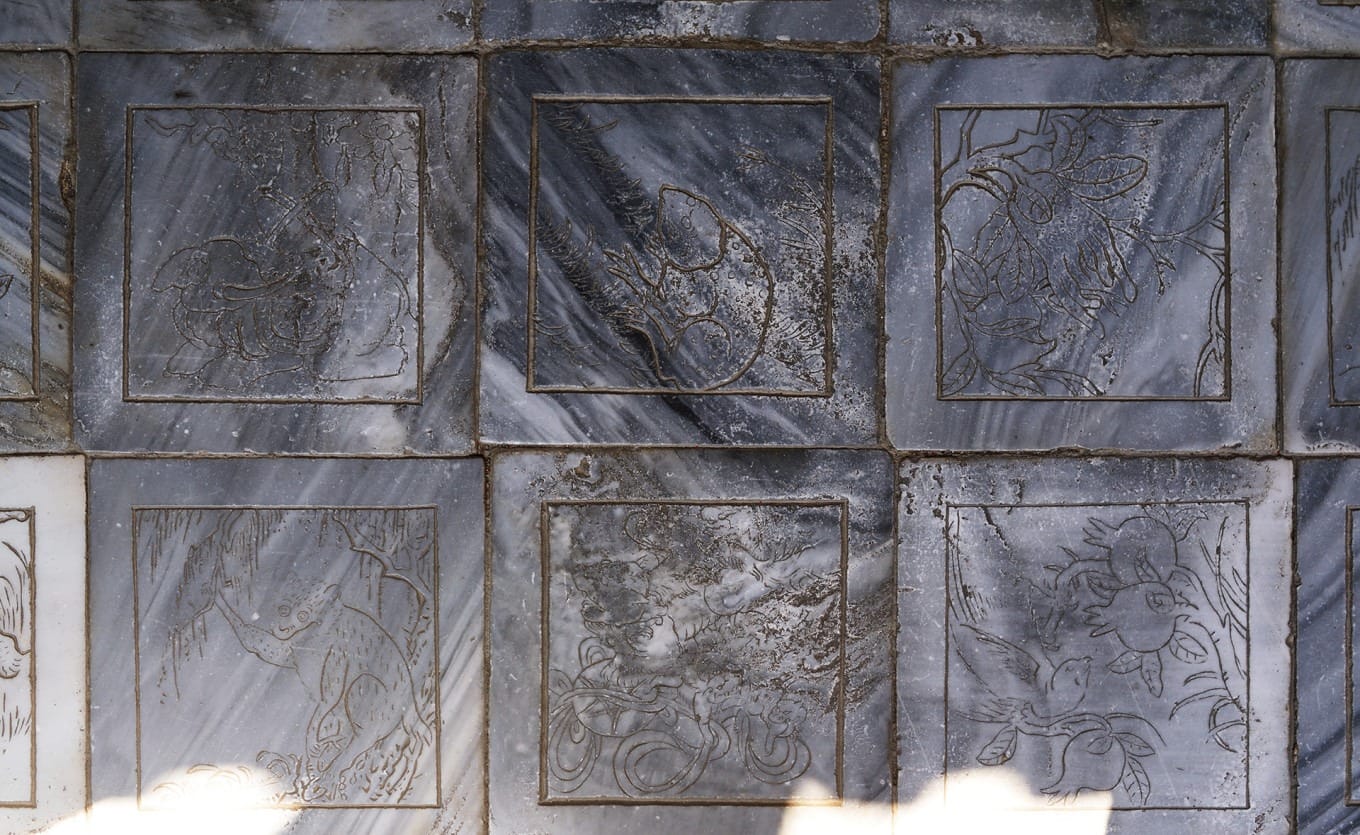 Intricately carved marble floor tiles with floral and animal motifs