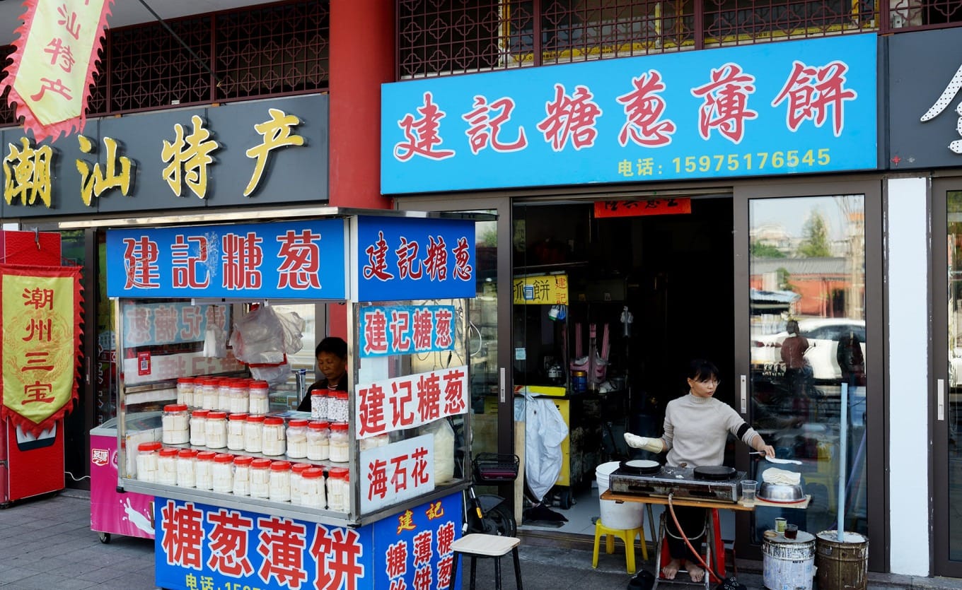 Artisan pulling molten sugar to create traditional Chaoshan sugar scallion candy