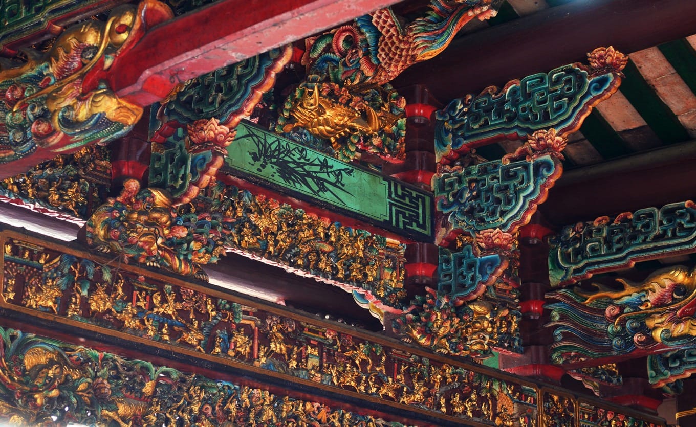 Detailed gold lacquer wood carvings on temple beams and brackets