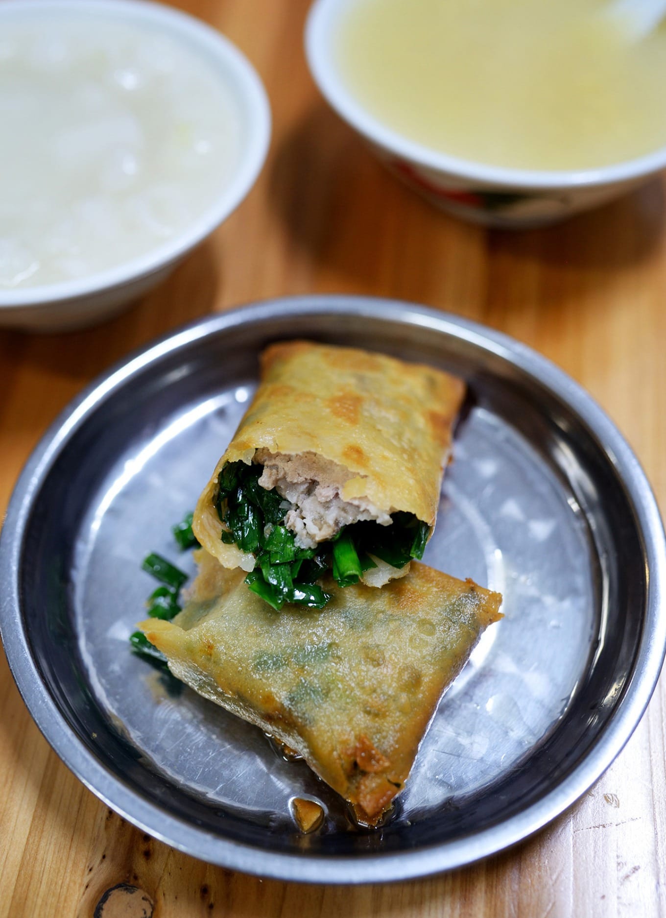 Crispy golden fried spring rolls stacked on a plate