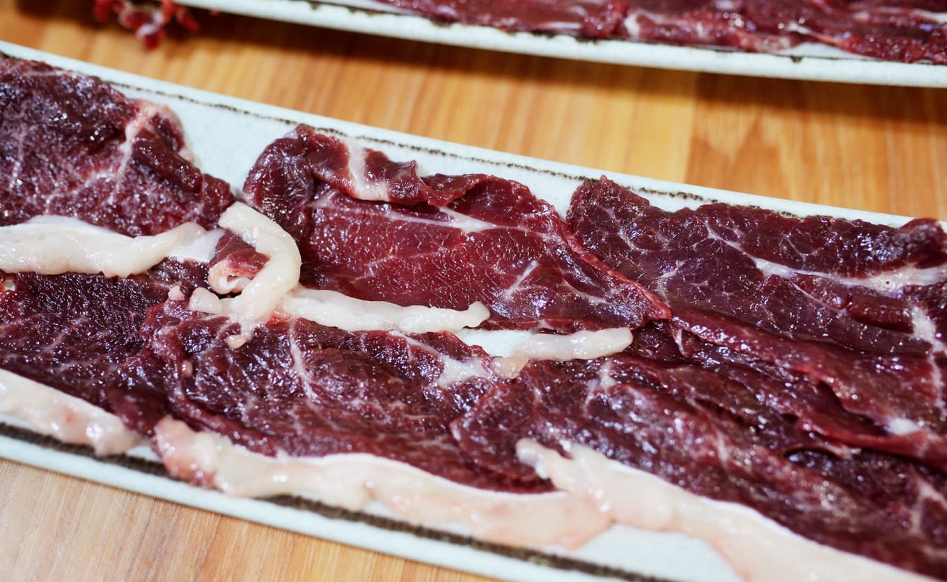 Raw Fatty Beef Belly slices showing distinct fat and meat layers for hotpot