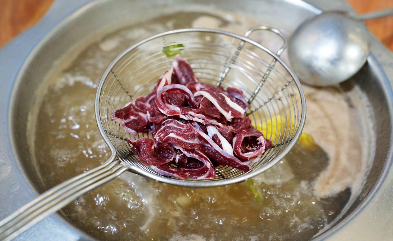 Freshly sliced Five-Flower Tendon beef arranged on plate showing layered texture