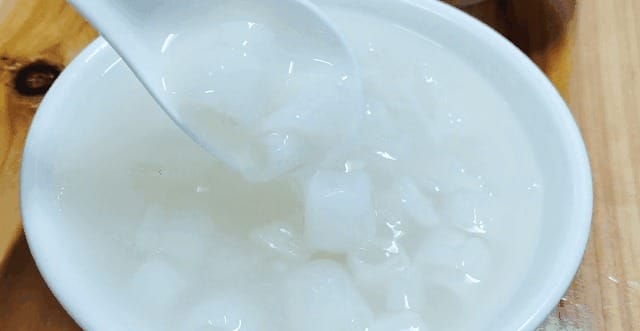 Bowl of Jiangshu Sweet Soup with thin curled white slices floating in clear syrup