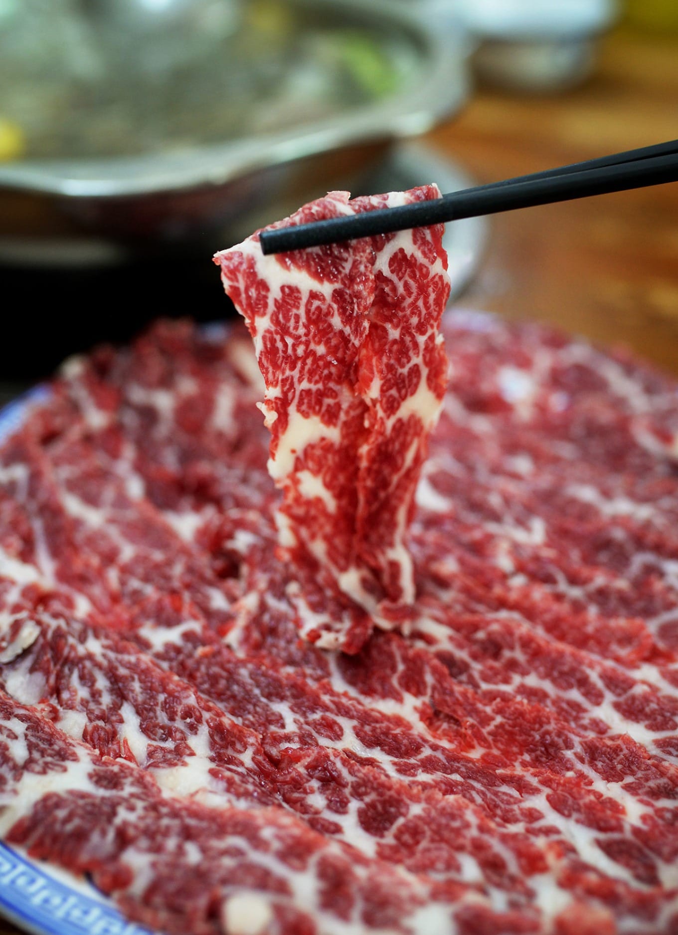 Freshly sliced Snowflake Beef with visible marbling on white plate
