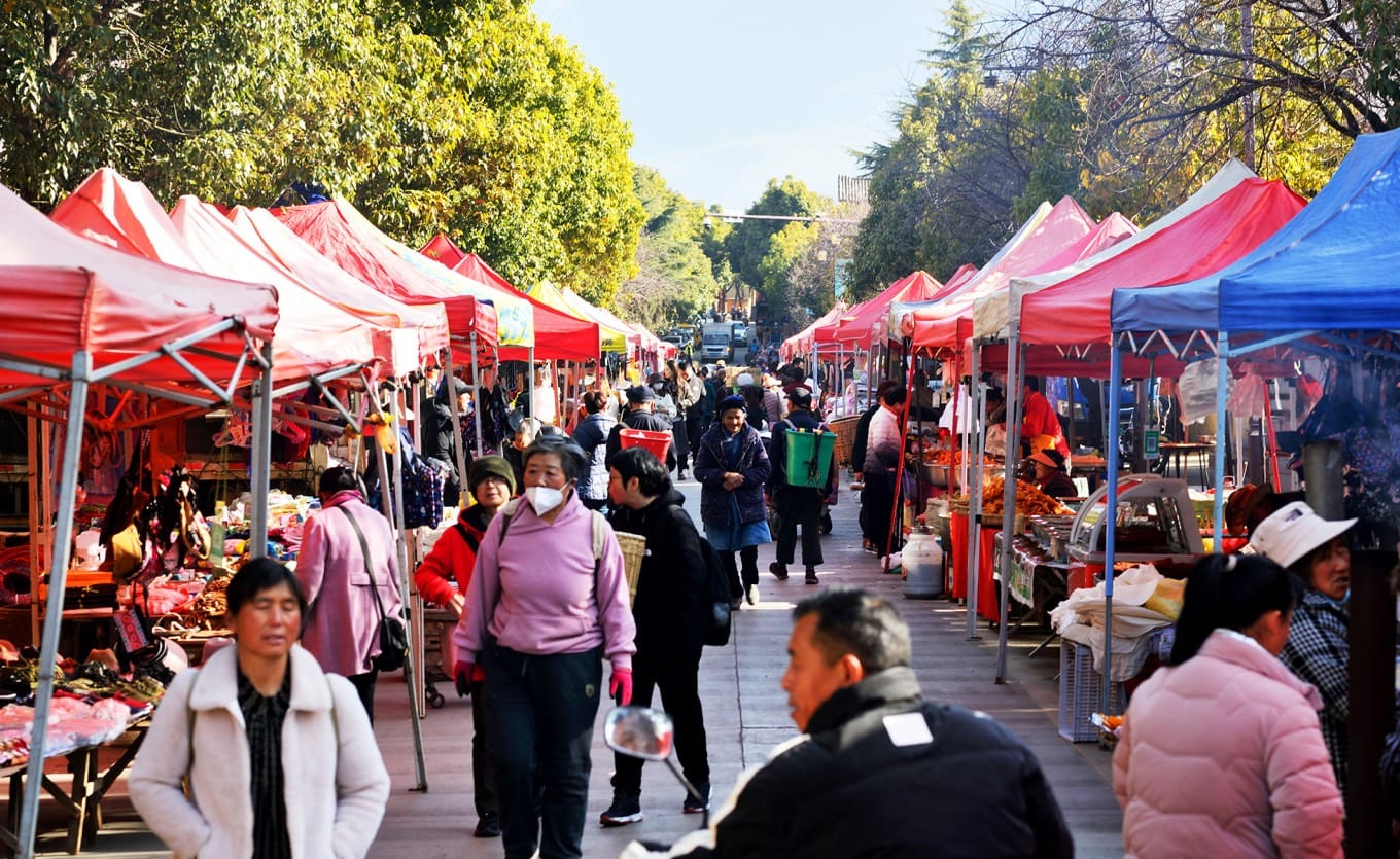 Vendor displaying fresh vegetables at Shaxi market