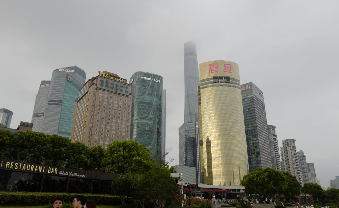 Shanghai skyscrapers disappearing into low-hanging clouds at twilight
