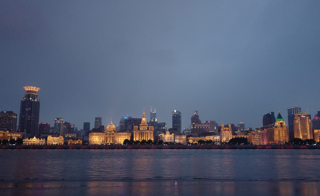 Wide panoramic view of Shanghai's Bund and Pudong skylines illuminated at night