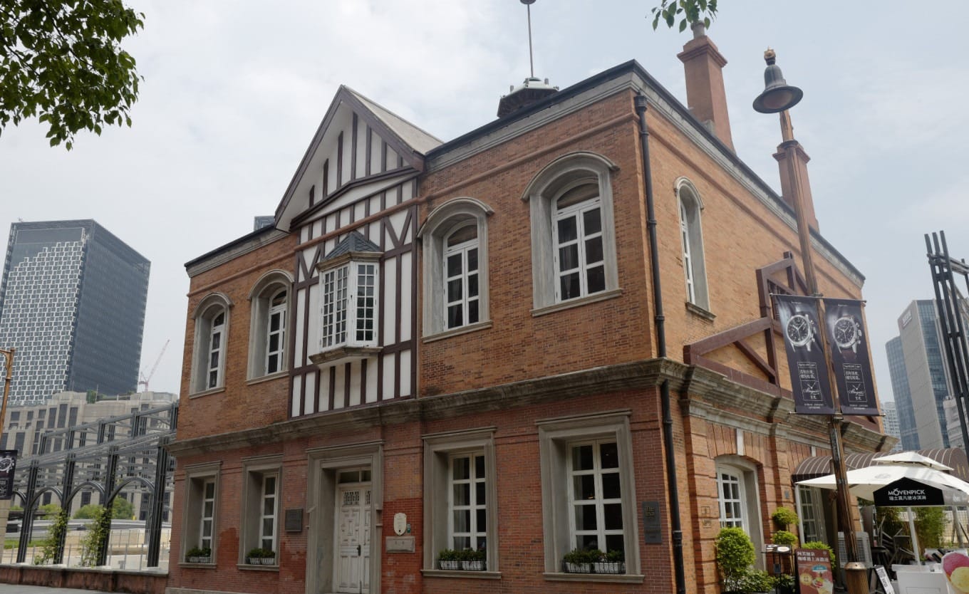 Former Rowing Club building with arched windows and waterfront location