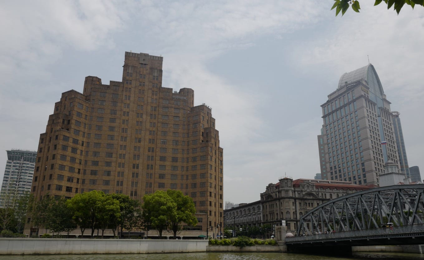 The imposing facade of the historic Shanghai Mansions building along the Suzhou Creek