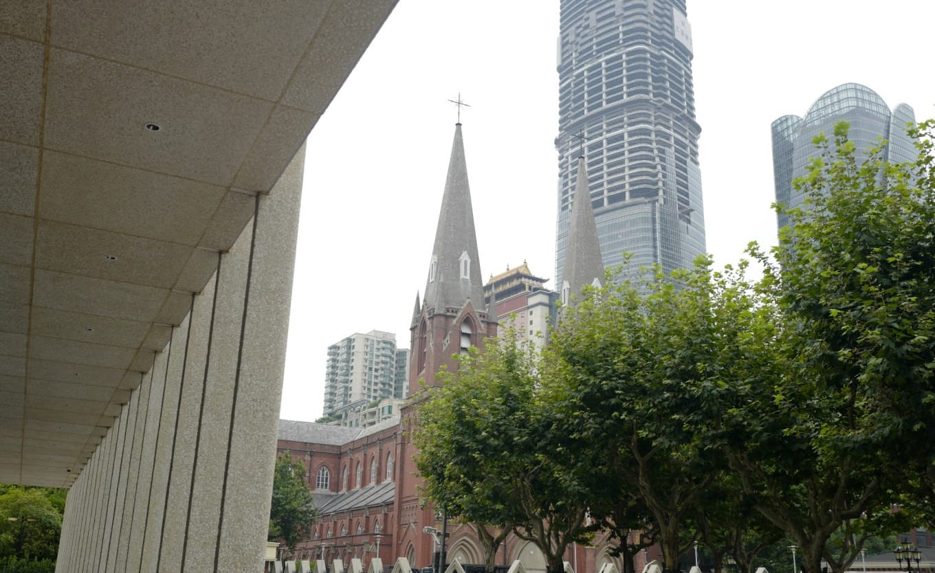 View from under the Xujiahui Library colonnade, with the Tibet Mansion and cathedral spires visible
