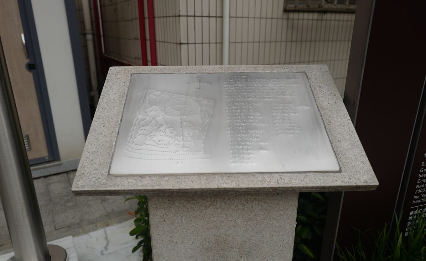 Close-up of a Braille information sign with tactile paving leading to it in Guangqi Park
